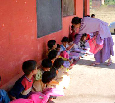 Mataji distributing food and shawls to poor children of a school near Rishikesh